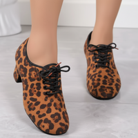 Leopard print shoes with black laces on a light background