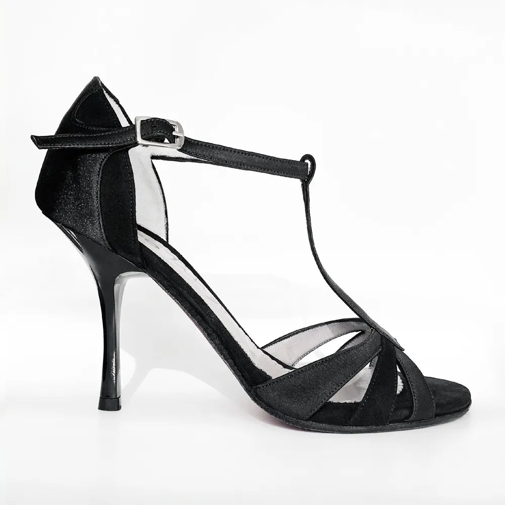 A single black high-heeled dance shoe with a T-strap, ankle strap with a silver buckle, and open toe, shown against a plain white background.